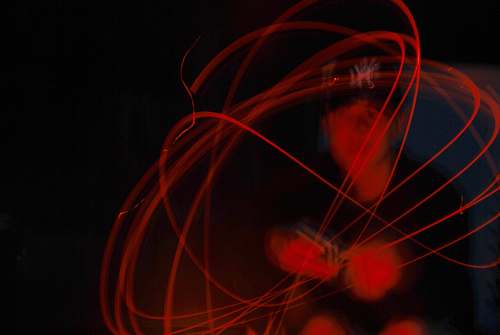 light timelapse photography of man writing on wall illuminated